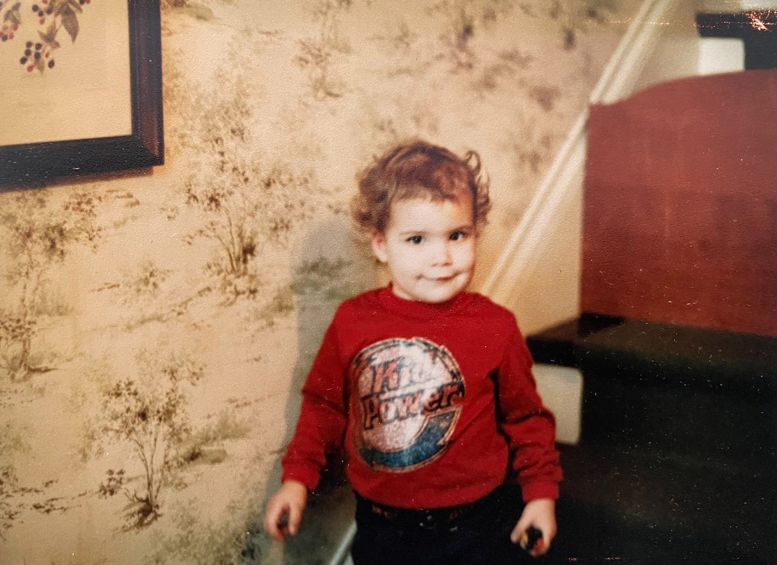 itty bitty Kristen with her baby curls wearing her favorite Kid Power sweatshirt long before she had any idea she was autistic