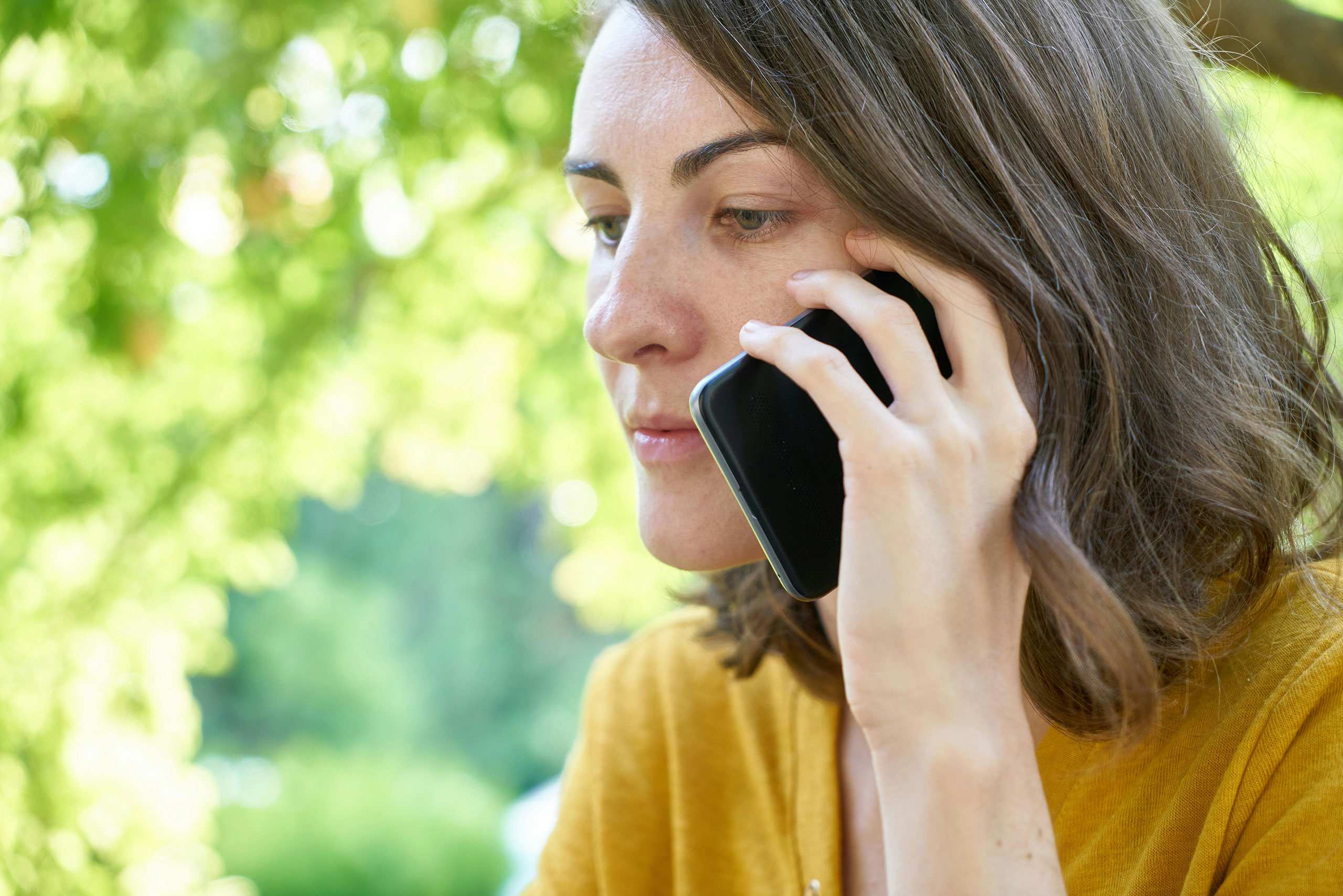 unsmiling person talking on a mobile phone